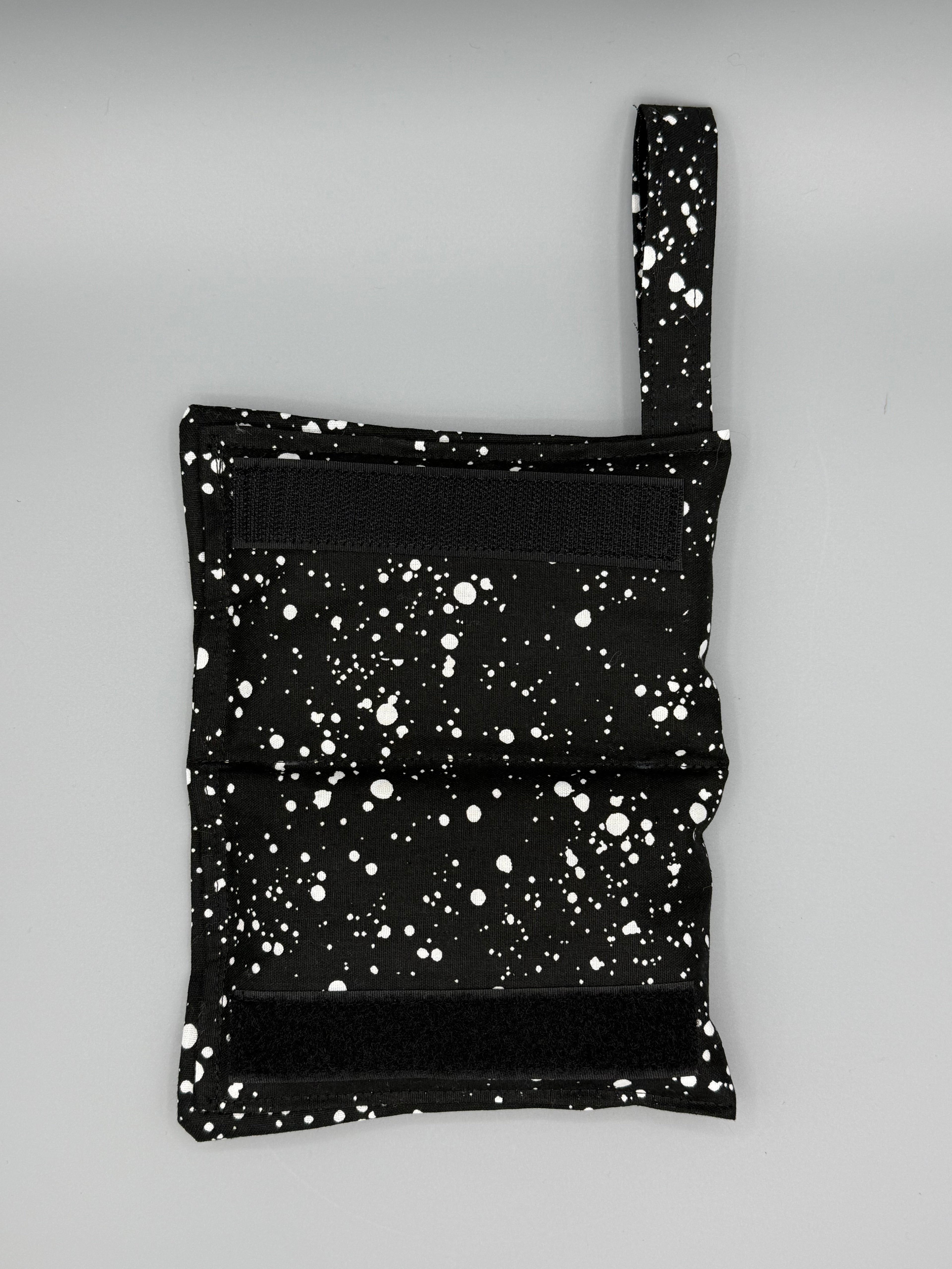 Black and White Speckled horse bit warmer open with velcro inside displayed