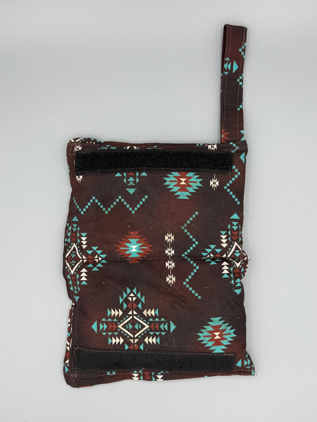 Brown Aztec horse bit warmer open with velcro inside displayed