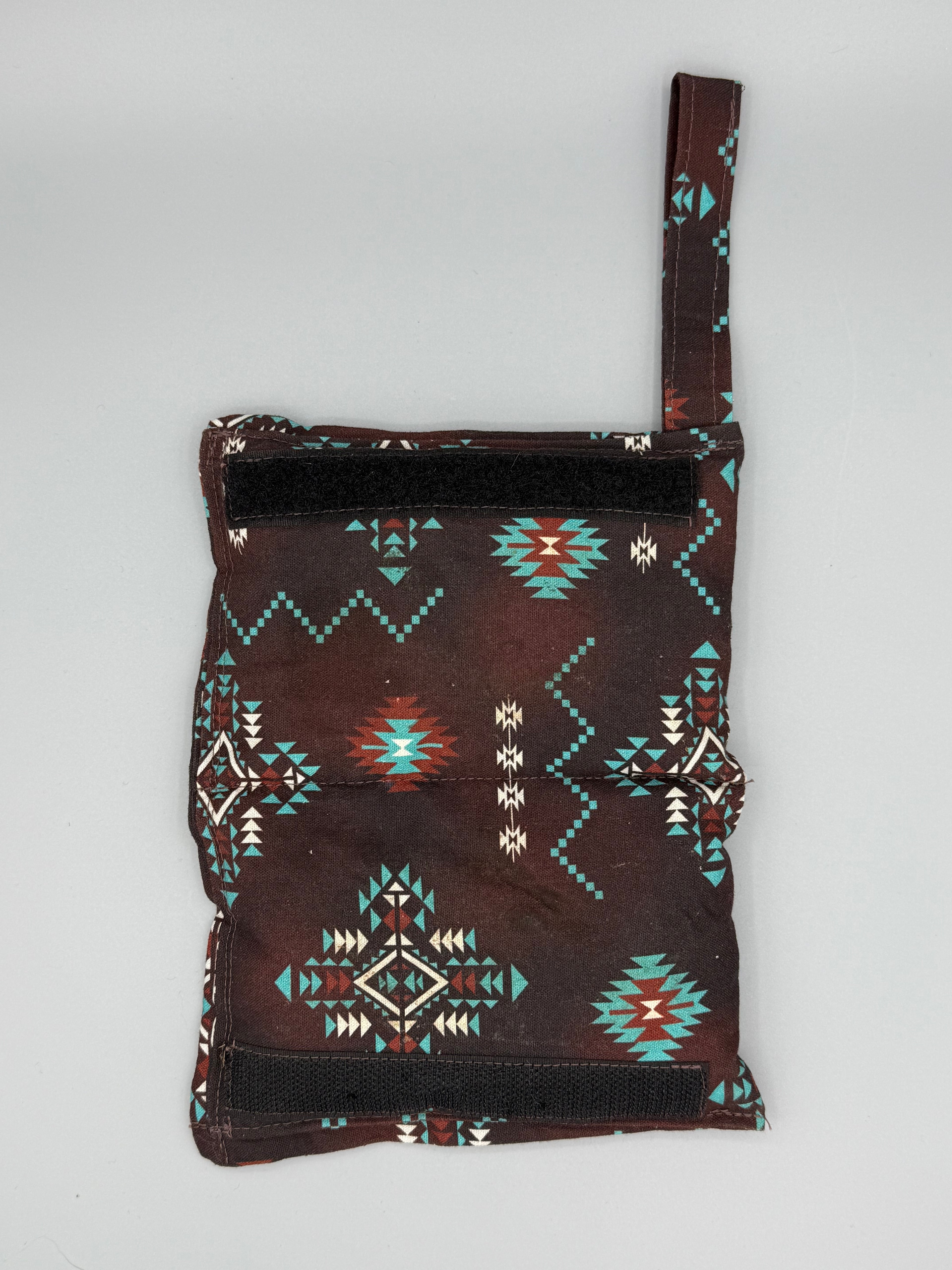Brown Aztec horse bit warmer open with velcro inside displayed