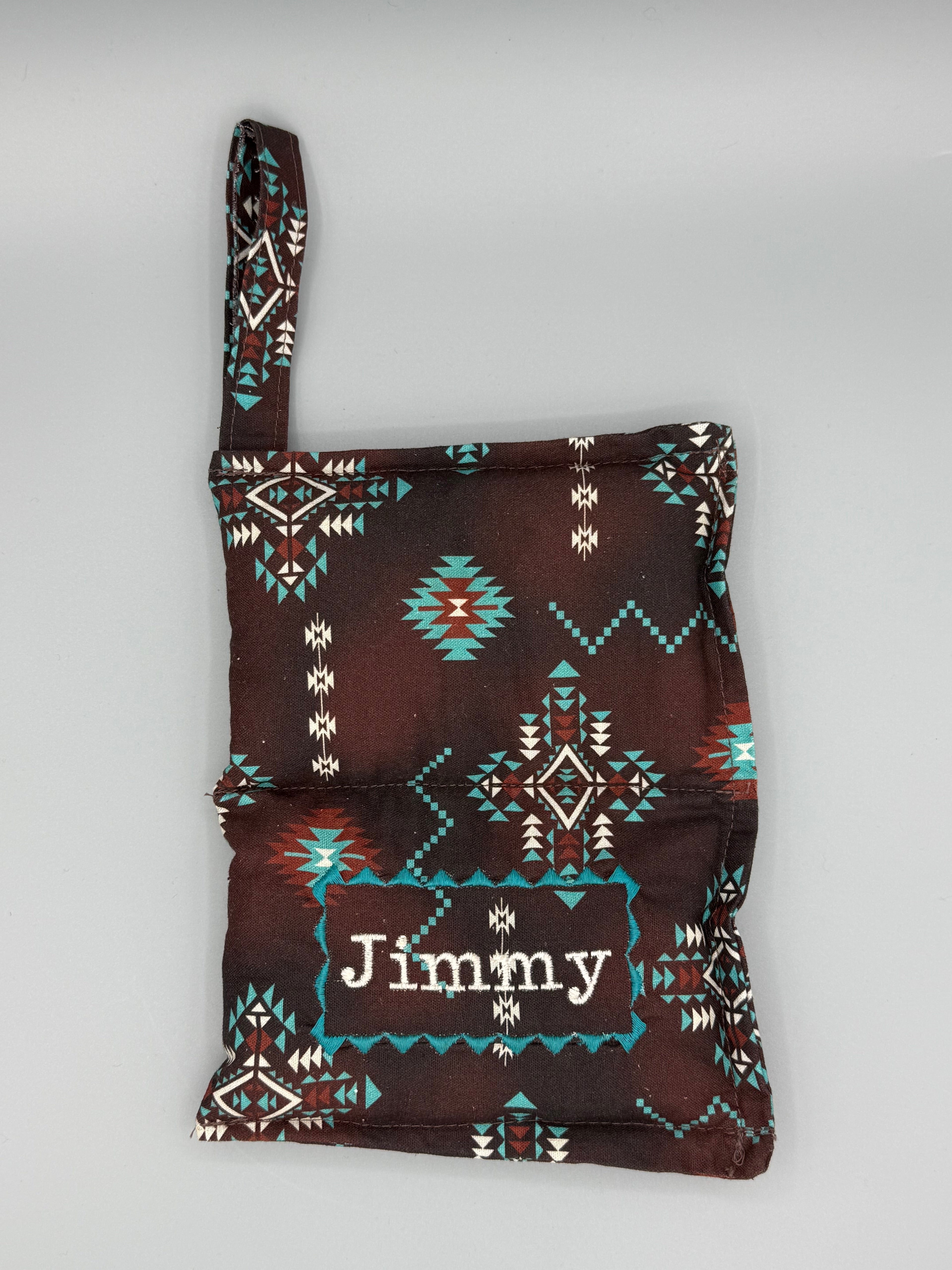 Brown Aztec horse bit warmer open with outside displayed