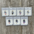 Collection of equestrian charms  in packaging on a wood background