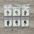 Packages of cowboy boot charms on wood background