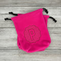 Pair of hot pink stirrup covers with embossed 'P' monogram on wood background. 