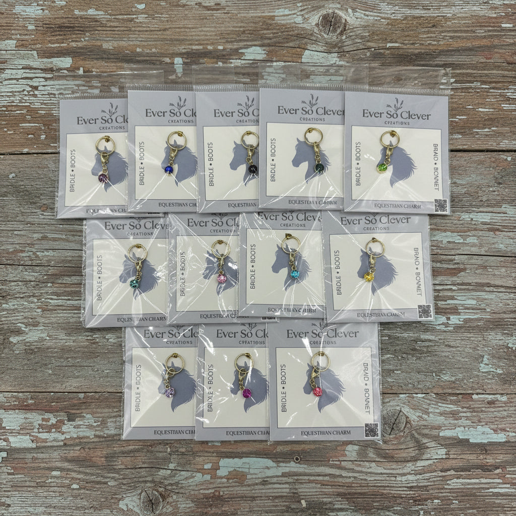 Multiple packages of Ever So Clever Creations gemstone charms  on a wood surface