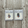 Two packages of Ever So Clever Creations love apple charms on a wood background