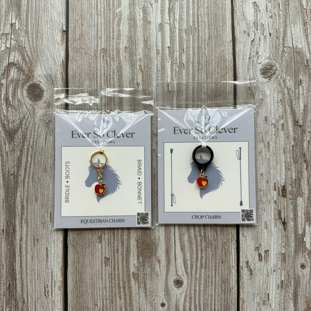 Two packages of Ever So Clever Creations love apple charms on a wood background