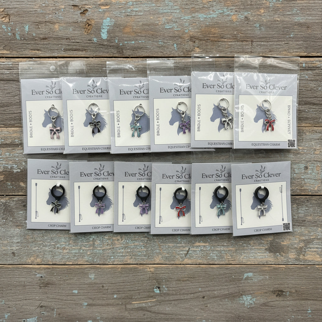 Packages of silver bow charms on wood surface