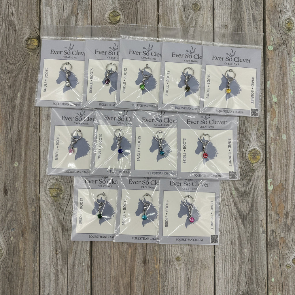 Silver gemstone charms in Ever So Clever Creations packaging on wood background
