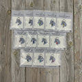 Silver gemstone charms in Ever So Clever Creations packaging on wood background