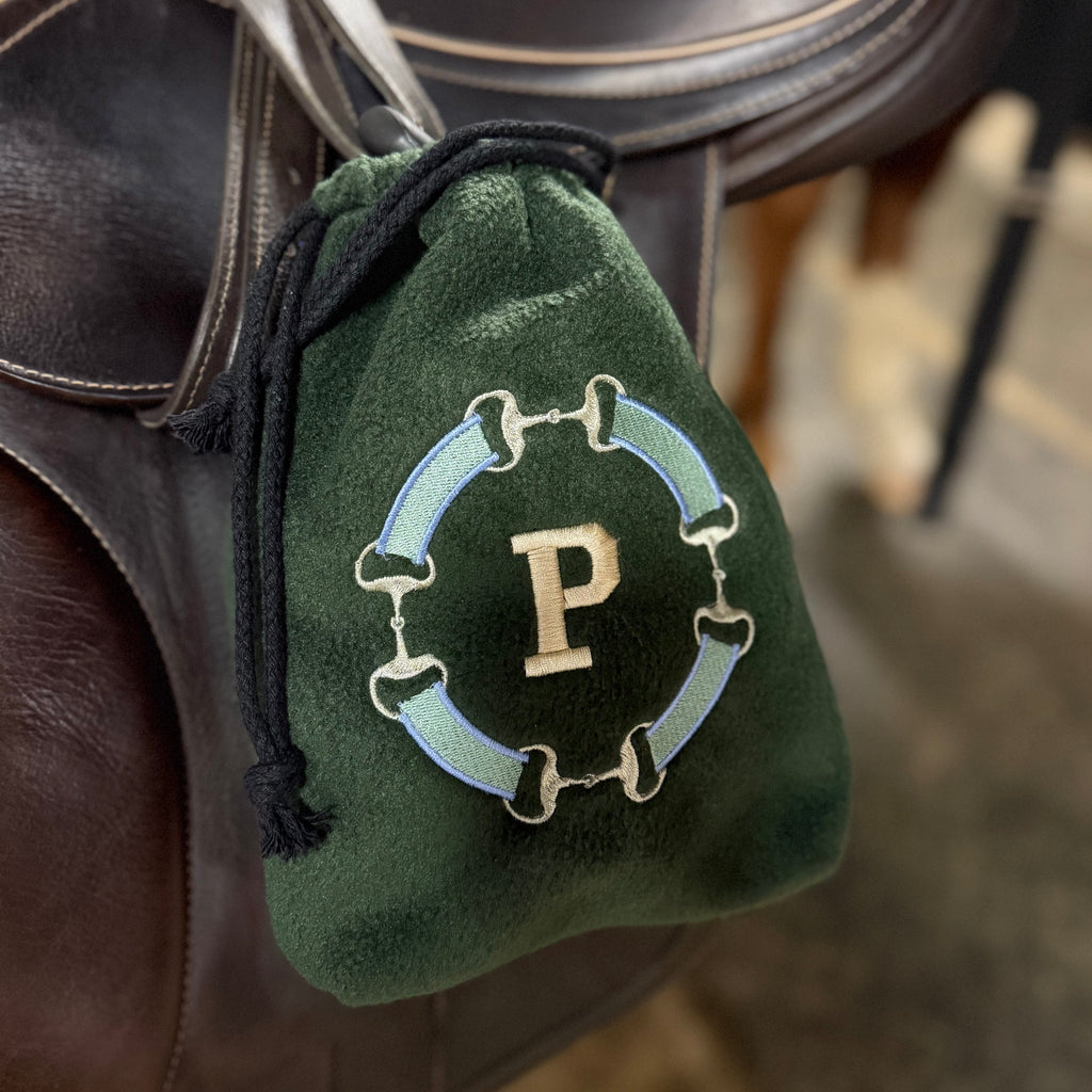 Green snaffle bit monogram stirrup cover with 'P' on stirrup iron/saddle. 
