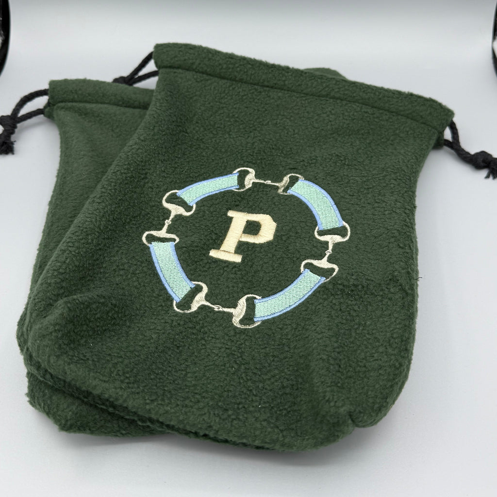 Green stirrup covers with snaffle bit 'P' monogram on a gray background.