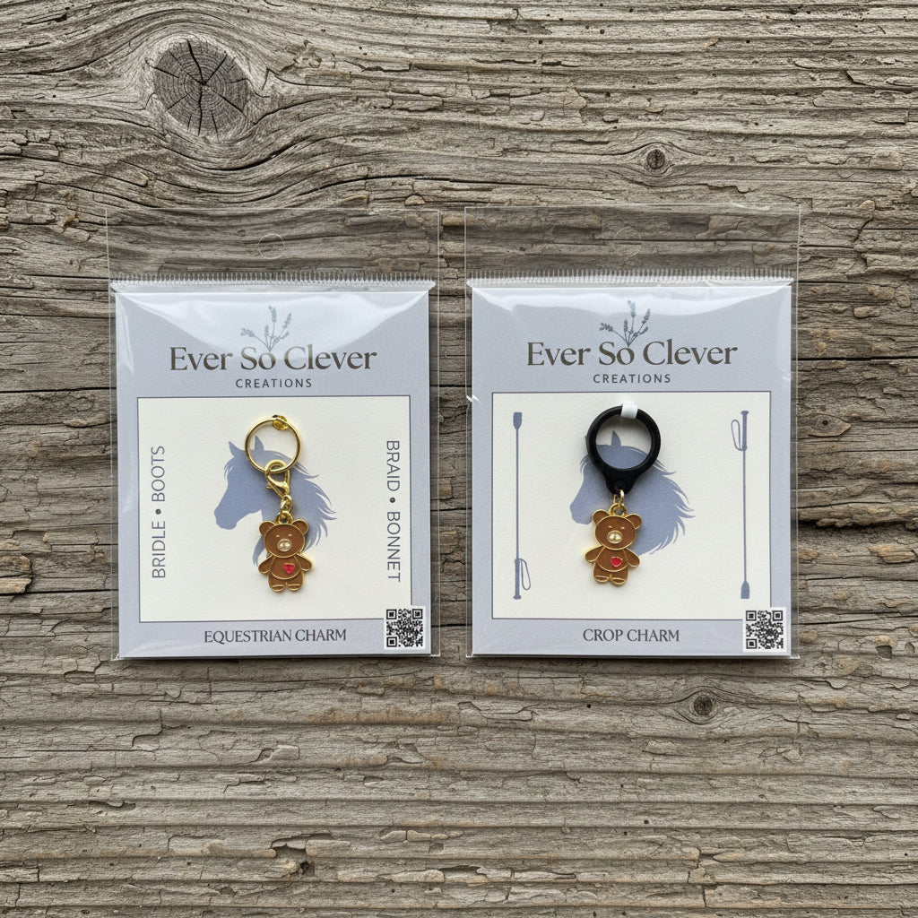 Two packages of Ever So Clever Creations teddy bear charms on a wood background